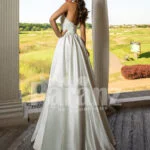 Closed neck and open back flared satin wedding gown with tulle skirt underneath back side view