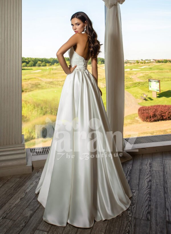 Closed neck and open back flared satin wedding gown with tulle skirt underneath back side view