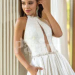 Closed neck and open back flared satin wedding gown with tulle skirt underneath close view