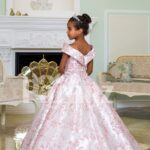 Criss-cross of shoulder style baby gown with flared and pleated high volume skirt back side view