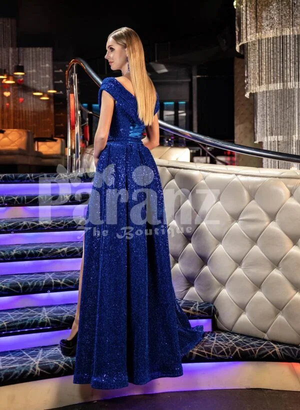 Elegant blue glitz evening gown with off-shoulder bodice and side slit skirt back side view