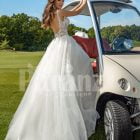 Flared and long tulle pearl white wedding gown with lacy bodice back side view