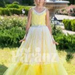 Light yellow sleeveless baby gown with rhinestone neckline and floor length tulle skirt