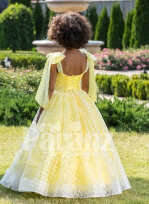 Light yellow sleeveless baby party gown with flared and floor length tulle skirt back side view