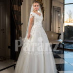 Pearl white cap sleeve floor length tulle wedding gown with floral bodice