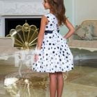 Rich satin sleeveless and sleek tea length party dress with black ball print all over back side view