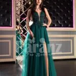 Womans stylish deep green evening gown with side slit tulle skirt and rich rhinestone bodice