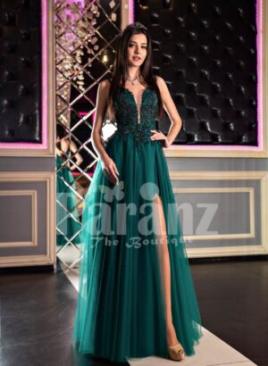 Womans stylish deep green evening gown with side slit tulle skirt and rich rhinestone bodice