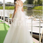Women’s beautiful lacy floral bodice tulle skirt wedding gown in white back side view
