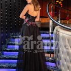Women’s beautiful off-shoulder black tulle skirt gown with colorful floral appliquéd bodice back side view