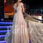 Women’s beautiful off-shoulder side slit party gown with off-shoulder bodice in beige back side view