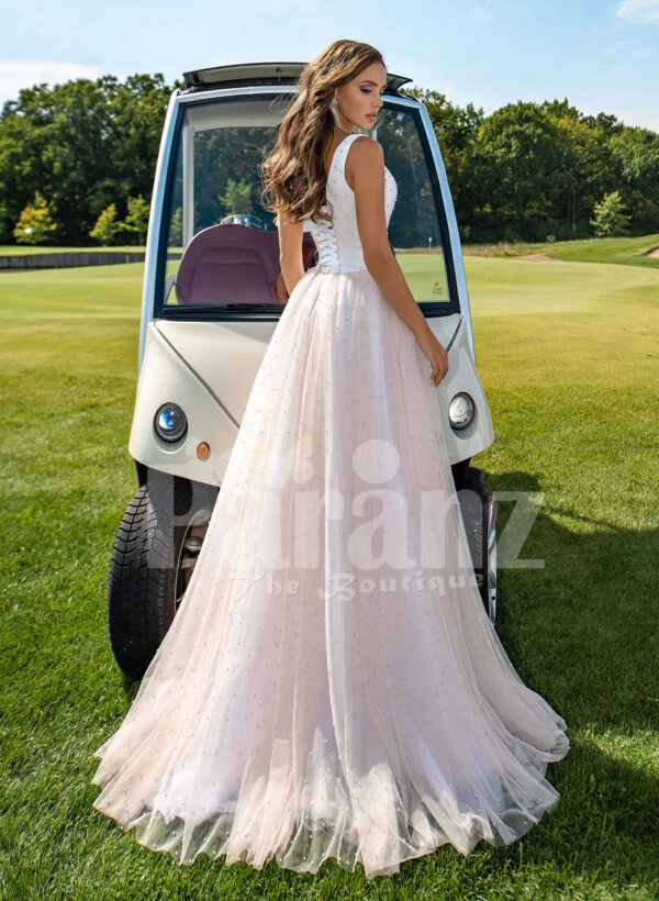 Women’s beautiful power pink-white wedding tulle gown with criss-cross lock back back side view