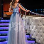 Women’s elegant evening gown with side slit tulle skirt and royal appliquéd bodice back side view