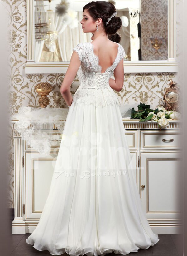 Women’s elegant pearl white floor length wedding gown with super lacy bodice and tulle skirt back side view