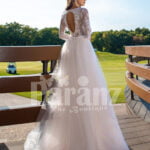 Women’s elegant pearl white tulle wedding gown with royal bodice three quarter sleeves back side view