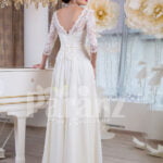 Women’s elegant white lacy bodice floor length tulle skirt wedding gown back side view