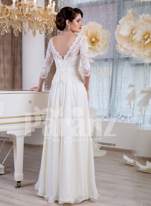 Women’s elegant white lacy bodice floor length tulle skirt wedding gown back side view