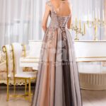 Women’s exclusive evening gown with rich royal appliquéd bodice with floor length tulle skirt back side view