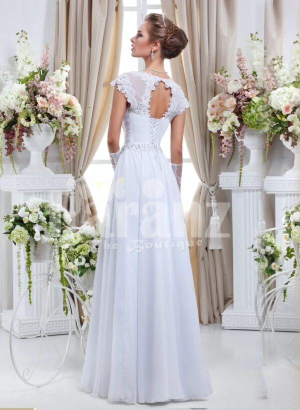 Women’s floor length sleek satin wedding gown with floral lace work in white back side view