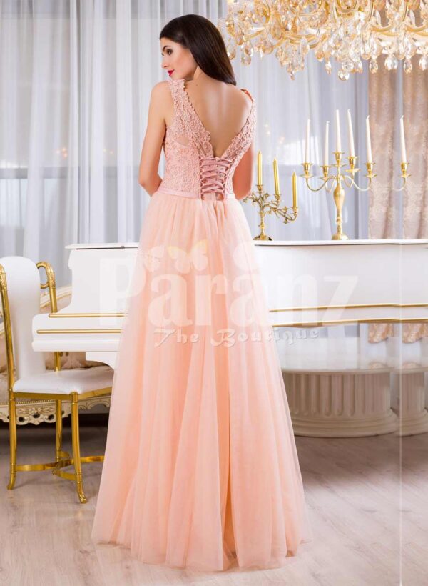 Women’s floor length tulle skirt evening gown with appliquéd bodice in peach hue back side view
