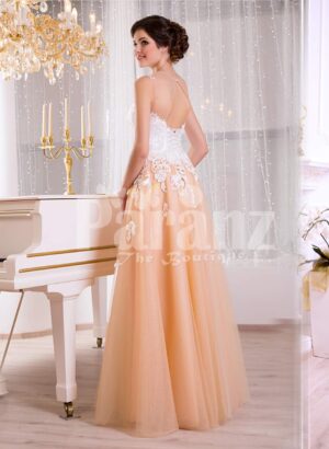 Women’s glam evening gown with peachy orange flared tulle skirt and appliquéd white bodice side view
