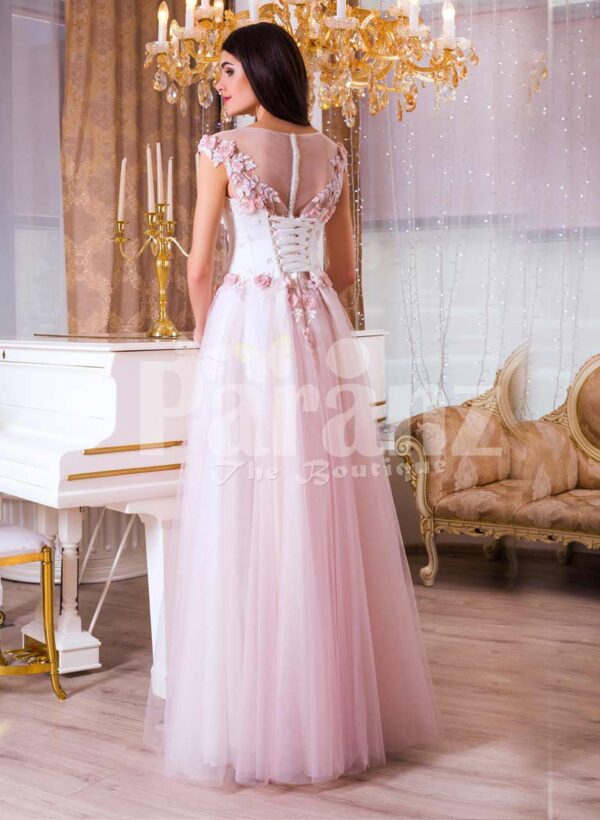 Women’s light pink evening gown with long tulle skirt and pink flower appliquéd bodice back side view