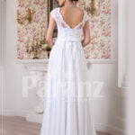 Women’s simple and elegant all white floor length lacy bodice wedding gown back side view