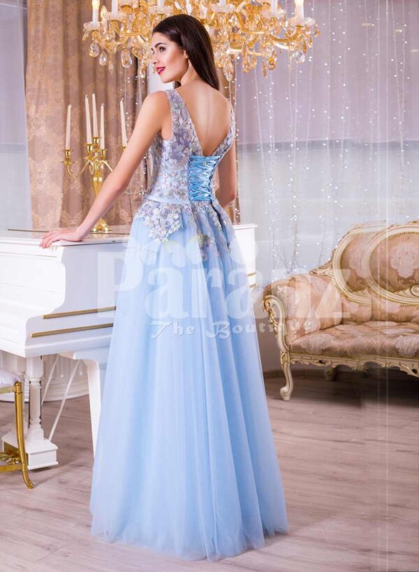 Women’s sleeveless evening gown with floor length tulle skirt and flower appliquéd bodice back side view