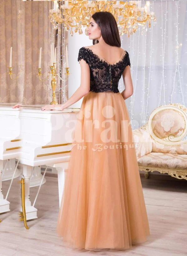 Women’s stunning evening gown with lacy black bodice and long peach tulle skirt back side view