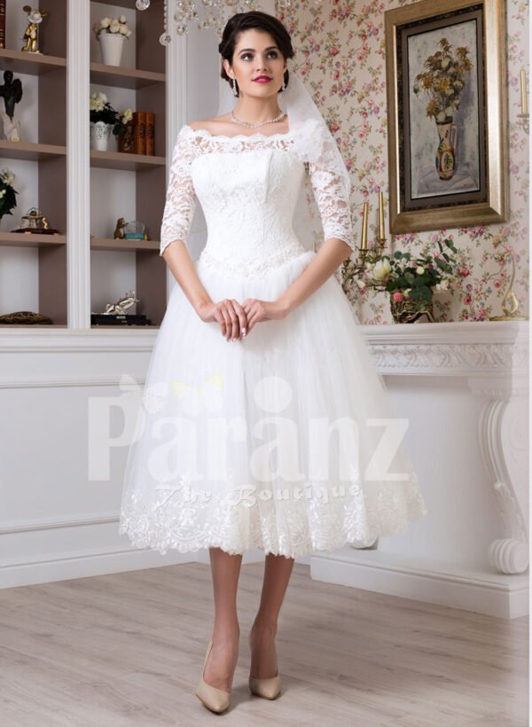 Women’s tea length white lacy bodice and tulle skirt wedding gown