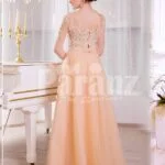 Women’s truly glam evening gown with long peachy orange tulle skirt and satin bodice back side view