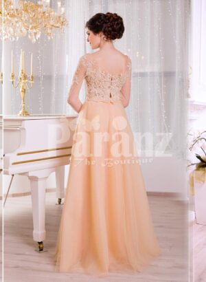 Women’s truly glam evening gown with long peachy orange tulle skirt and satin bodice back side view