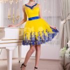 Bright yellow small evening gown with short tulle skirt and rich blue lace work