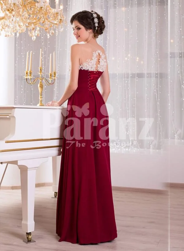 Women’s deep maroon floor length sleek tulle skirt dress with white flower appliquéd bodice side view