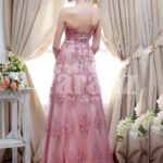 Women’s metallic pink off-shoulder evening party gown with floor length lace work skirt back side view